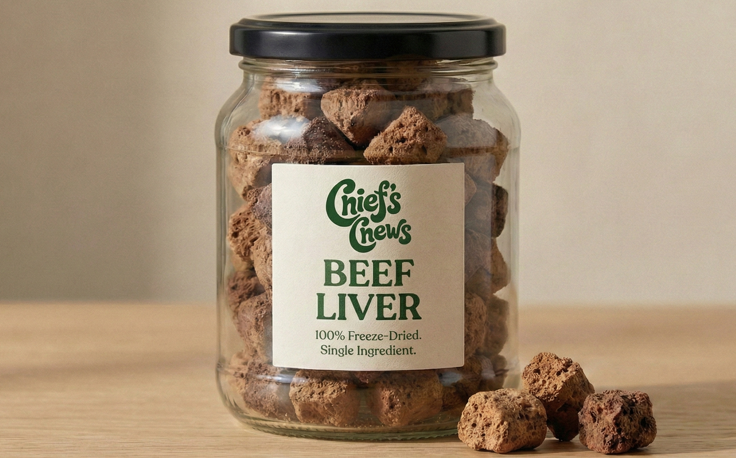 Jar of Chief's Chews Beef Liver treats on a wooden surface with a beige background
